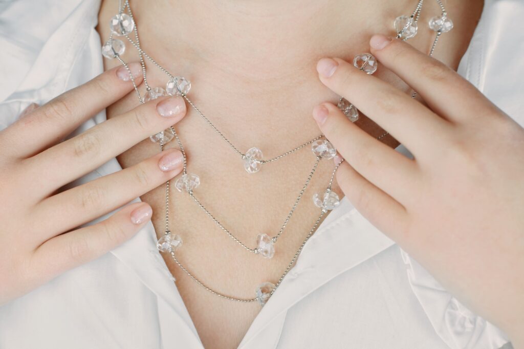 young woman wearing crystal necklace, crop view.